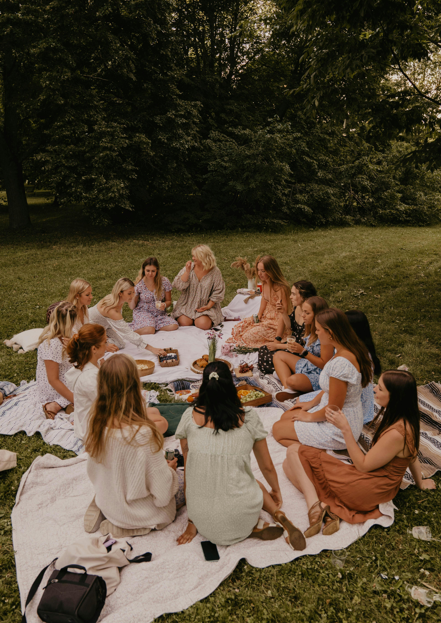 Gruppe von Frauen auf einer Picknickdecke auf einer Rasenfläche